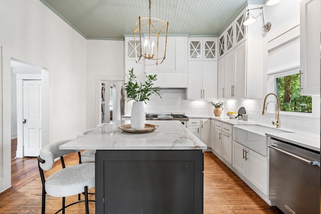 1502 W Virginia St, Mckinney, TX 75069 - kitchen with stainless steel dishwasher, a sink, a kitchen bar, a center island, and decorative backsplash