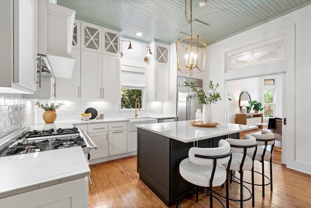 1502 W Virginia St, Mckinney, TX 75069 - kitchen featuring a sink, built in fridge, decorative backsplash, white cabinets, and a kitchen breakfast bar