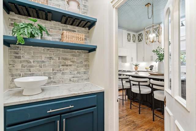 1502 W Virginia St, Mckinney, TX 75069 - bar with wood finished floors, a chandelier, and pendant lighting