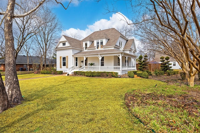 view of front of property featuring covered porch, a front lawn, and roof with shingles