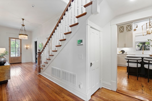 1502 W Virginia St, Mckinney, TX 75069 - entrance foyer with a chandelier, light wood finished floors, stairs, and baseboards