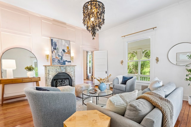 1502 W Virginia St, Mckinney, TX 75069 - living area featuring light wood-type flooring, ornamental molding, a fireplace, and a chandelier