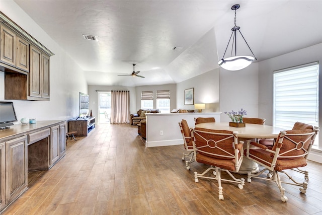 dining area with light wood-style floors, ceiling fan, visible vents, and baseboards