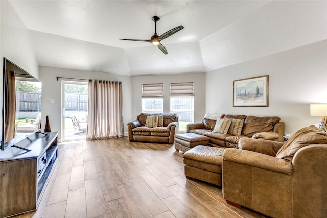 living area with lofted ceiling, ceiling fan, baseboards, and wood finished floors