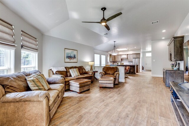 living room with a healthy amount of sunlight, visible vents, baseboards, and light wood finished floors