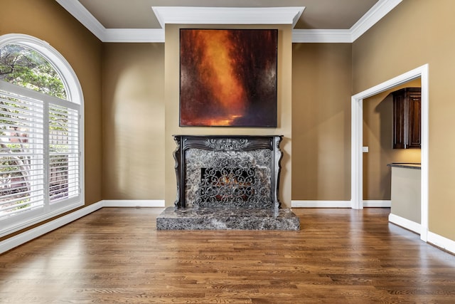 unfurnished living room featuring ornamental molding, a high end fireplace, baseboards, and wood finished floors