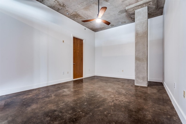 unfurnished room featuring a ceiling fan, concrete flooring, and baseboards