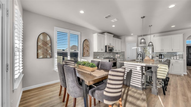 dining area featuring light wood-style floors, baseboards, visible vents, and recessed lighting