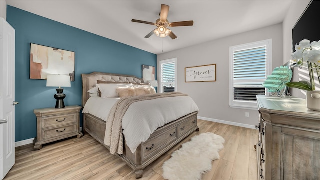 bedroom featuring ceiling fan, light wood-style flooring, and baseboards