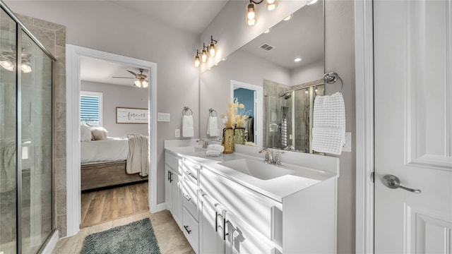 full bath featuring double vanity, visible vents, connected bathroom, a shower stall, and a sink