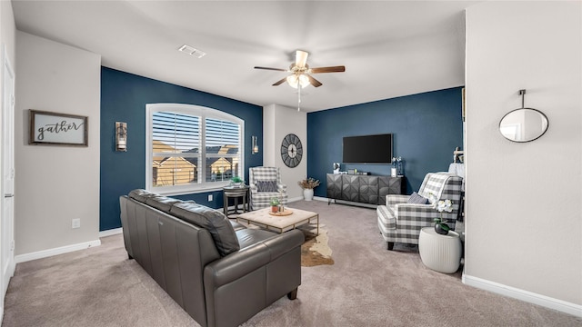 living room with light carpet, a ceiling fan, visible vents, and baseboards