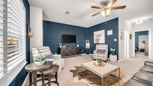 carpeted living room with ceiling fan, visible vents, and baseboards