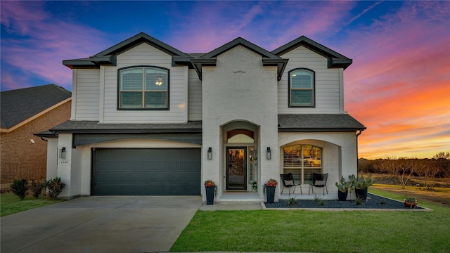 view of front of property with concrete driveway, an attached garage, covered porch, a front lawn, and brick siding