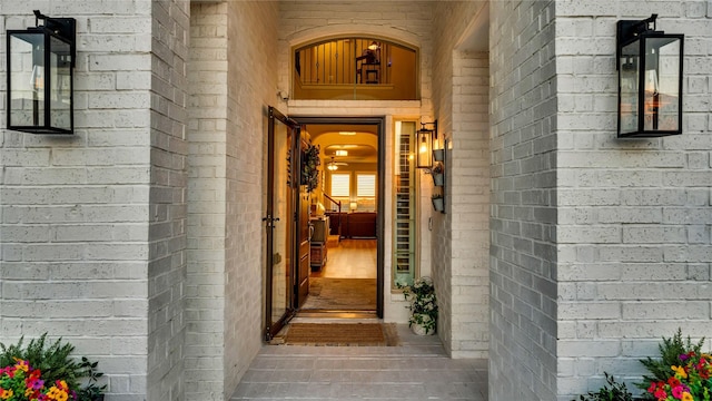 view of exterior entry featuring brick siding