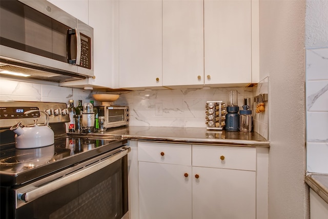 kitchen featuring backsplash, appliances with stainless steel finishes, and white cabinetry