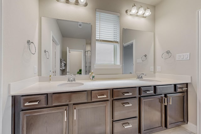 full bathroom with double vanity, marble finish floor, and a sink