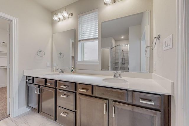 full bathroom with marble finish floor, a sink, a shower stall, and double vanity