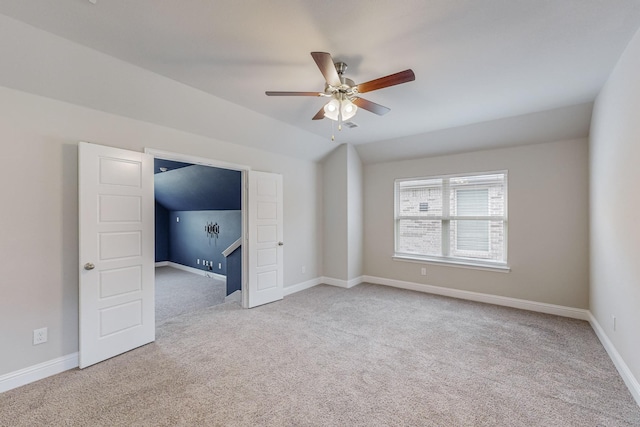 unfurnished room with ceiling fan, baseboards, vaulted ceiling, and carpet flooring