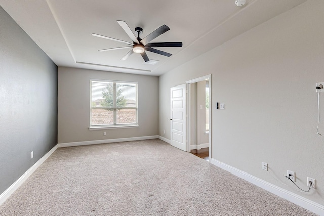 carpeted empty room featuring baseboards and a ceiling fan