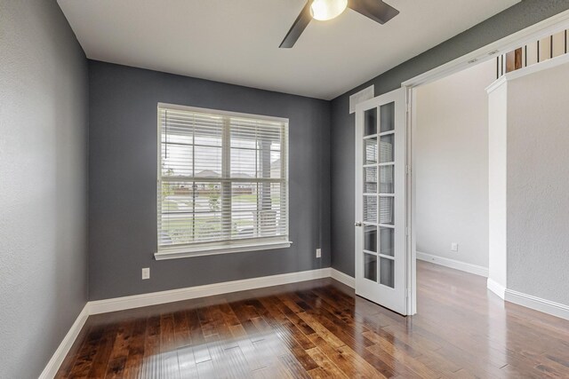 empty room featuring a ceiling fan, baseboards, and hardwood / wood-style floors