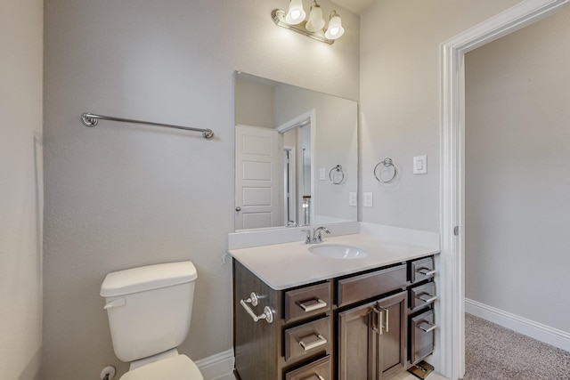 bathroom featuring toilet, baseboards, and vanity