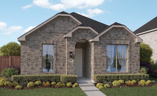 french country style house featuring fence and brick siding