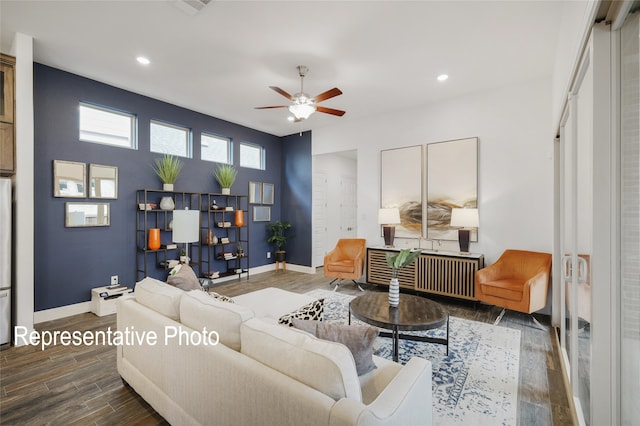 living area with radiator heating unit, wood finished floors, a ceiling fan, and baseboards