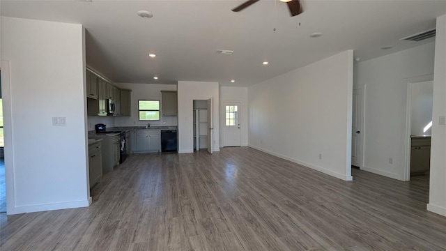 kitchen with stove, wood finished floors, visible vents, black dishwasher, and open floor plan