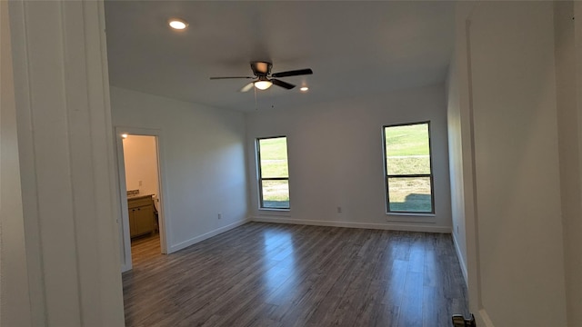 unfurnished bedroom with multiple windows, recessed lighting, dark wood finished floors, and baseboards