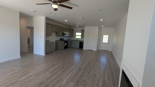 kitchen with visible vents, open floor plan, black appliances, light wood-type flooring, and baseboards