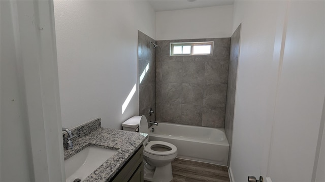 full bathroom featuring washtub / shower combination, vanity, wood finished floors, and toilet