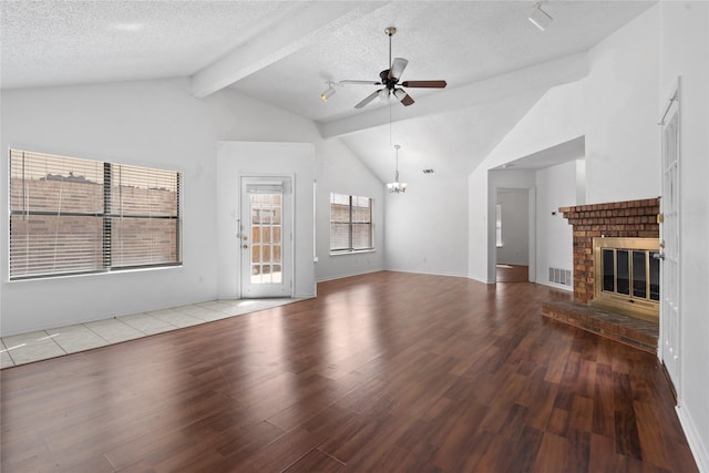 unfurnished living room featuring ceiling fan with notable chandelier, a fireplace, a textured ceiling, and wood finished floors