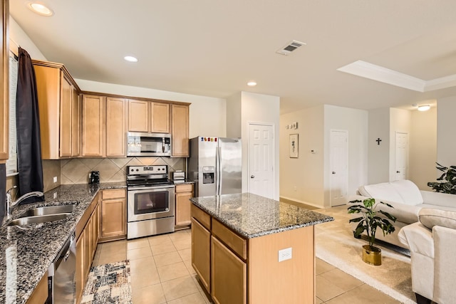 kitchen with appliances with stainless steel finishes, open floor plan, a sink, and light tile patterned floors