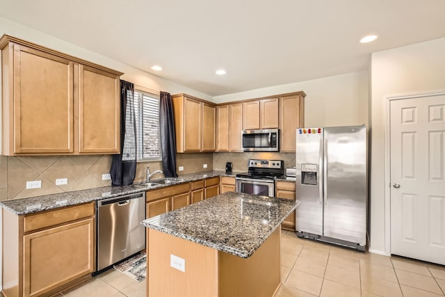 kitchen featuring appliances with stainless steel finishes, dark stone counters, a sink, and light tile patterned flooring