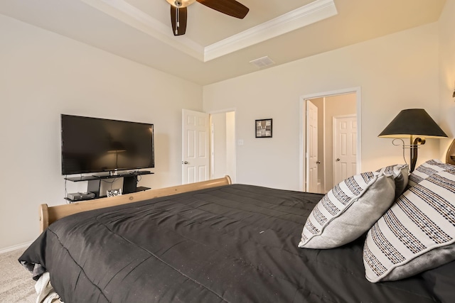 carpeted bedroom featuring ceiling fan, visible vents, baseboards, ornamental molding, and a raised ceiling