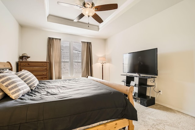 bedroom with carpet, a tray ceiling, baseboards, and ornamental molding