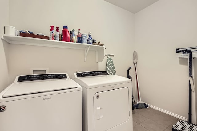 laundry area featuring laundry area, washing machine and dryer, light tile patterned floors, and baseboards