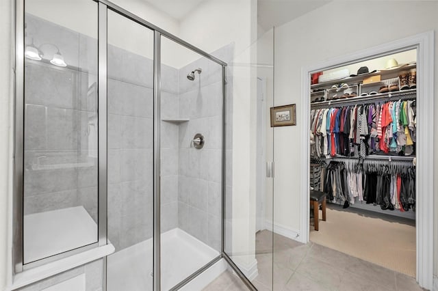 full bath featuring a stall shower and a walk in closet