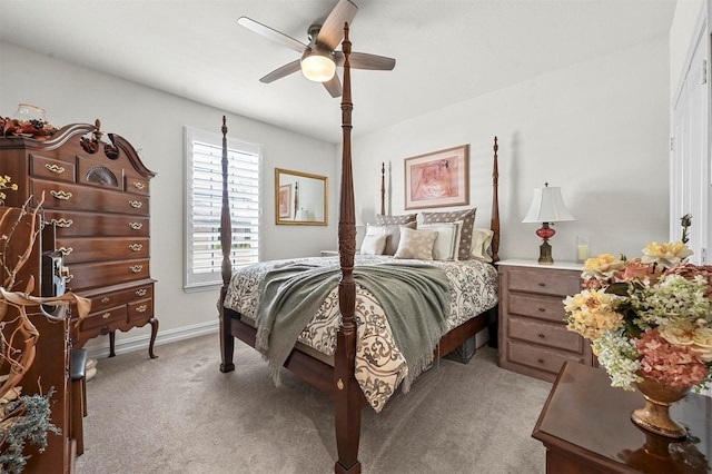 bedroom with light colored carpet, ceiling fan, and baseboards