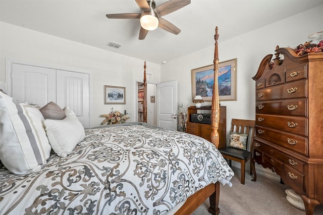 carpeted bedroom featuring a ceiling fan, a closet, and visible vents