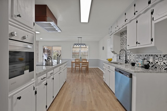 kitchen featuring stainless steel oven, dishwashing machine, wall chimney exhaust hood, black electric cooktop, and a sink