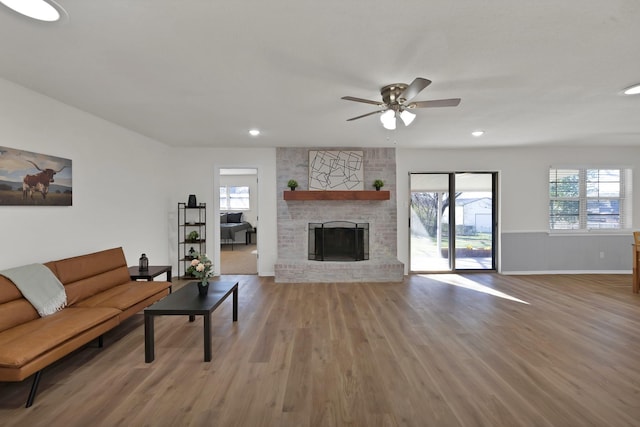 unfurnished living room featuring baseboards, light wood finished floors, recessed lighting, a fireplace, and ceiling fan