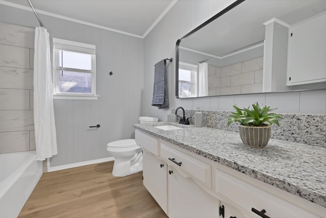 bathroom featuring toilet, a healthy amount of sunlight, wood finished floors, and crown molding