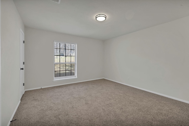 spare room with baseboards and carpet floors