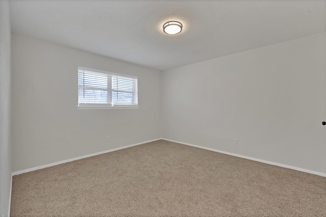 carpeted spare room with baseboards