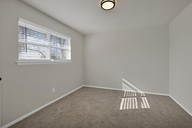 carpeted spare room featuring baseboards