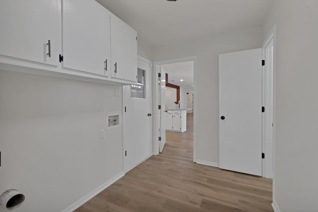 clothes washing area featuring hookup for a washing machine, cabinet space, light wood-type flooring, and baseboards