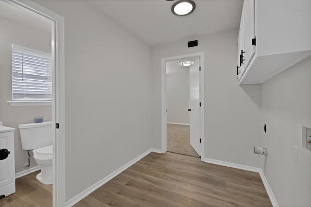 laundry room featuring light wood finished floors, laundry area, hookup for a washing machine, and baseboards