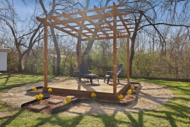 view of yard featuring a wooden deck, an outdoor fire pit, and fence