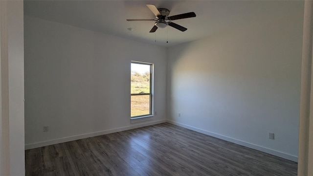 spare room featuring dark wood-style floors, ceiling fan, and baseboards